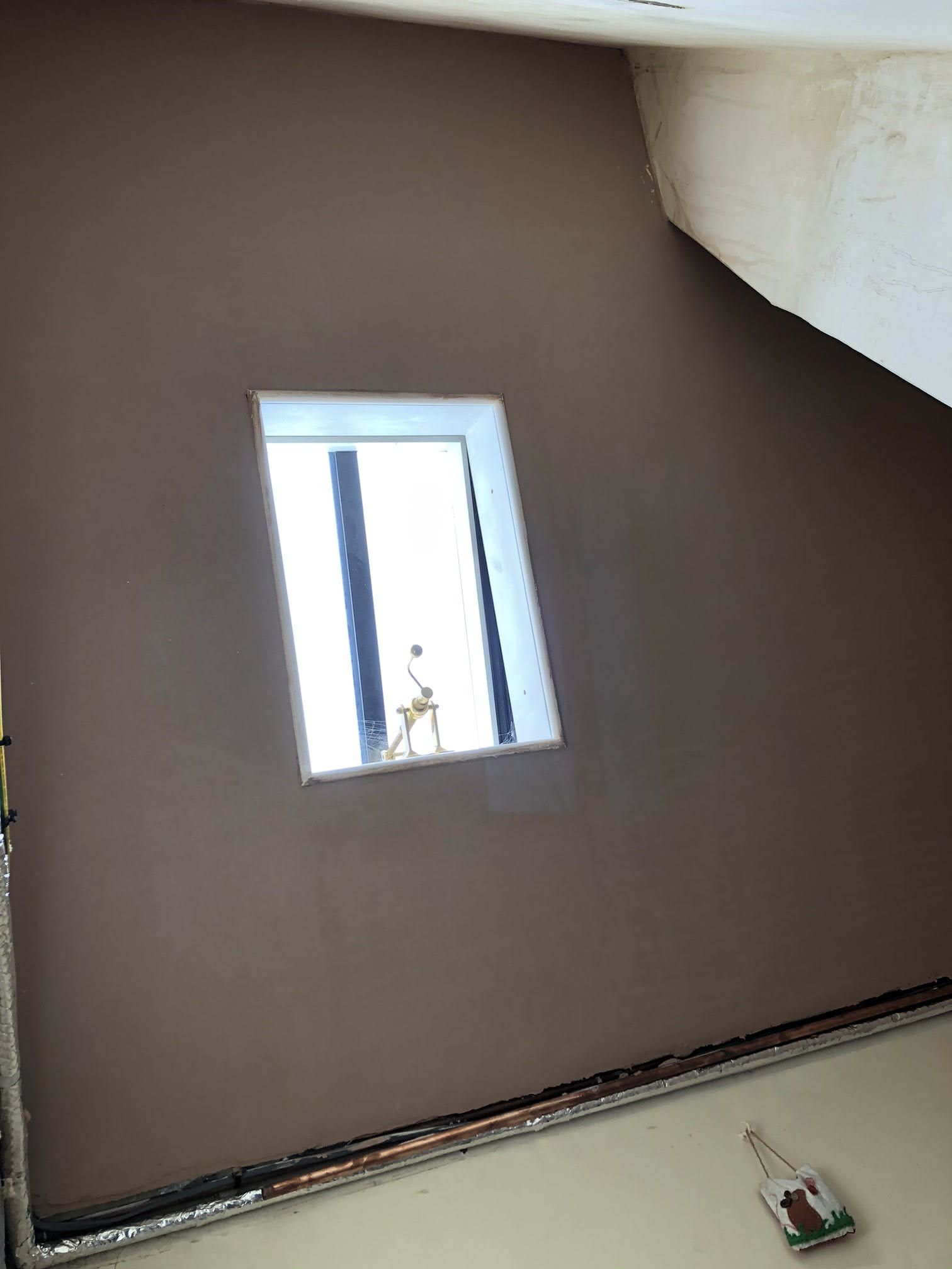 freshly plastered wall featuring square window