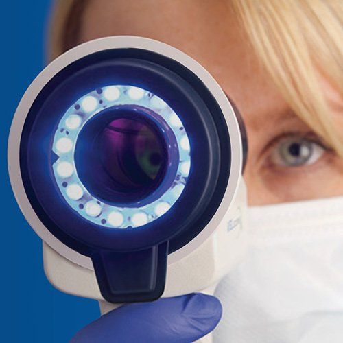 A woman looking through a dental scope