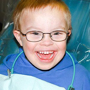 A child with down syndrome smiling at the dentist