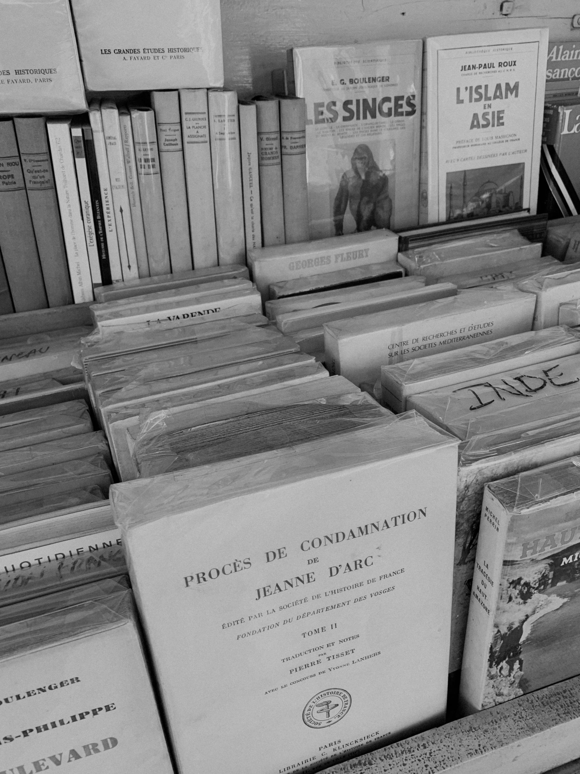 A black and white photo of a bookshelf filled with books.