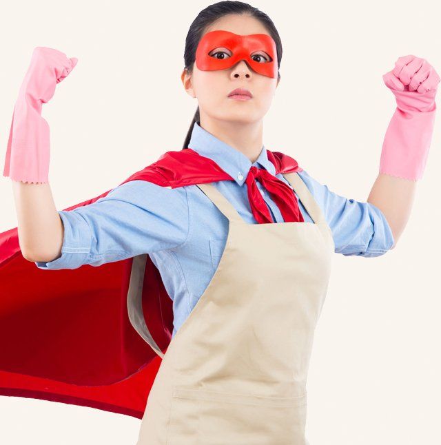 Cleaning woman in red superhero mask, cape, and pink gloves, flexing while wearing an apron.