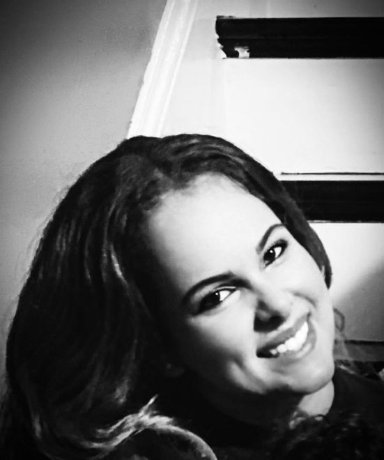 Woman with long dark hair, smiling widely. Black and white photo.