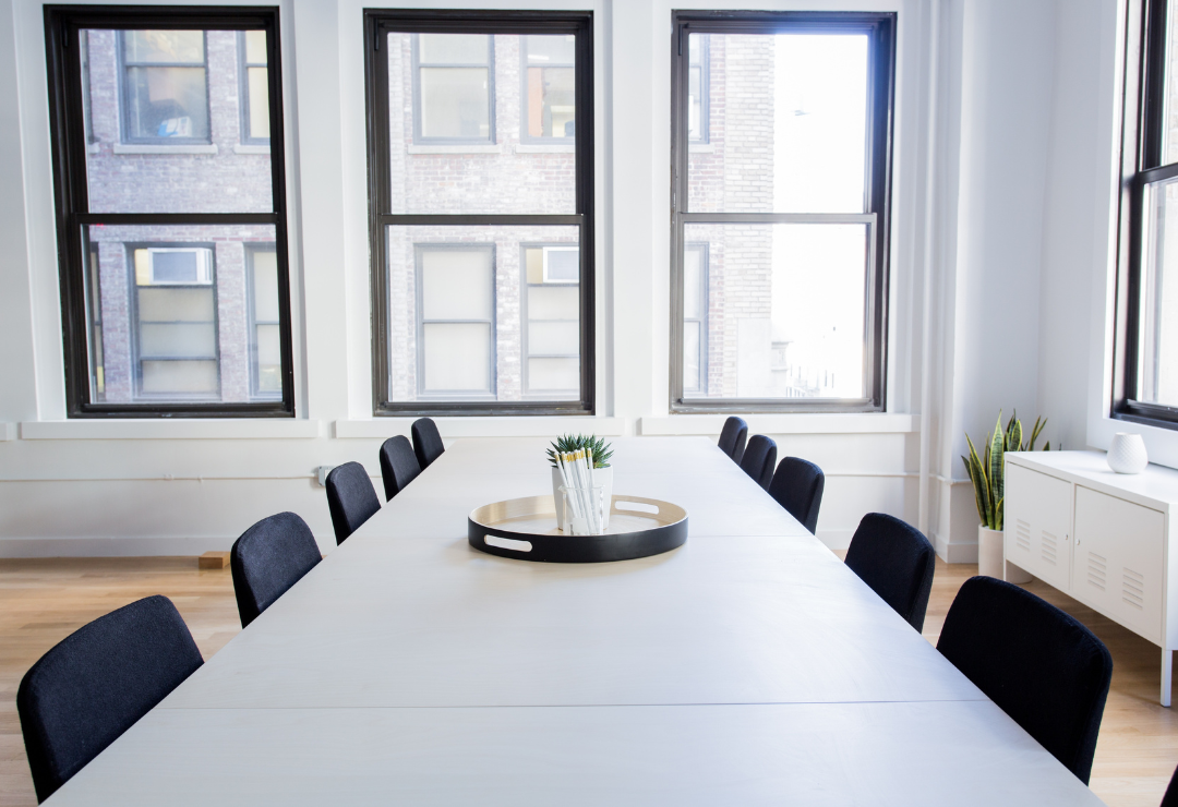 A long table with black chairs, for a conference room in an office.