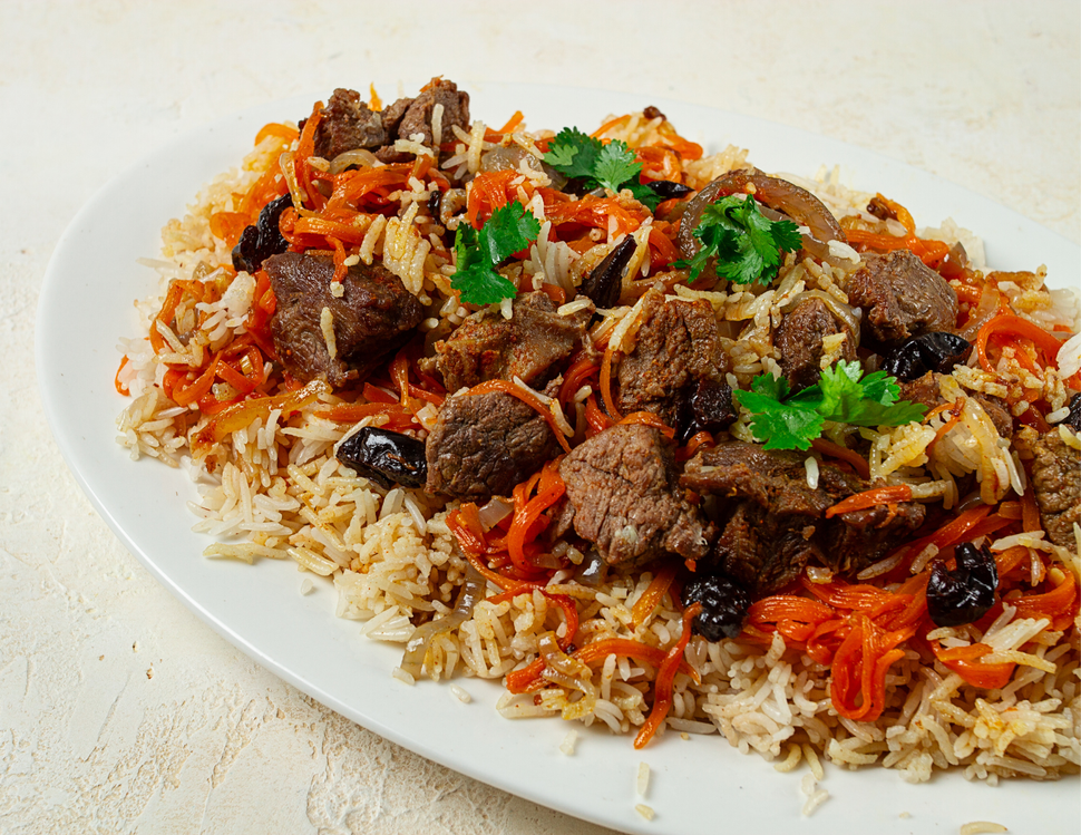 A white plate topped with rice , meat , carrots and raisins.
