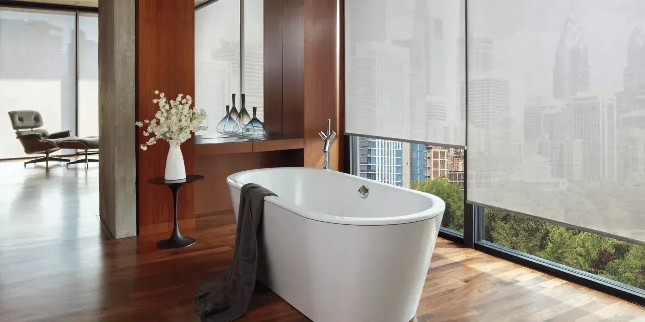 Neutral-toned Hunter Douglas screen shades in a bright and cozy office