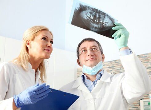 Dentist Studying the teeth - Cosmetic Dentistry in Farmingdale, NY