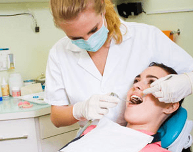 A woman having her teeth cleaned by her dentist