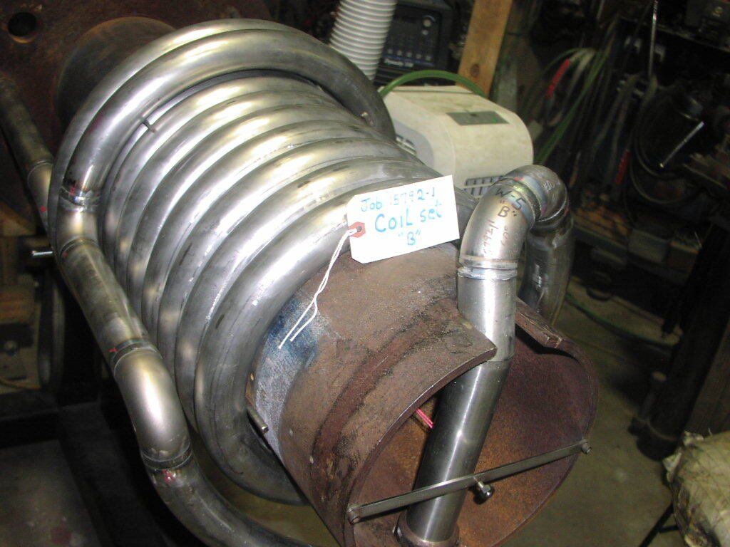 A stainless steel pipe is sitting on top of a rusty pipe.