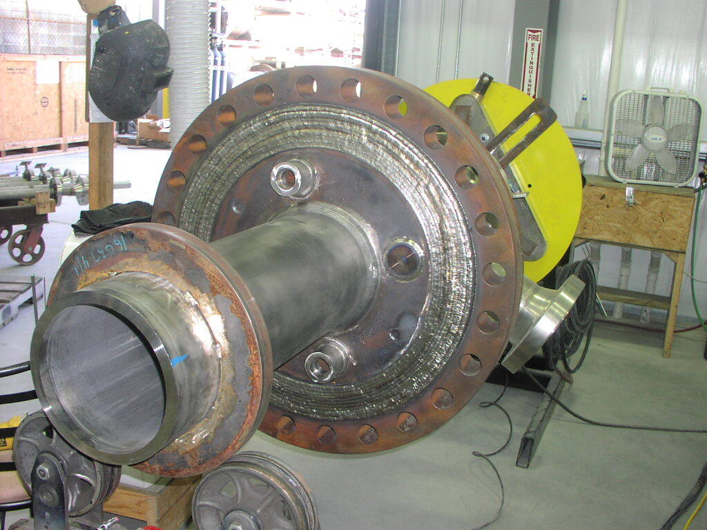 A large piece of metal is being worked on in a workshop