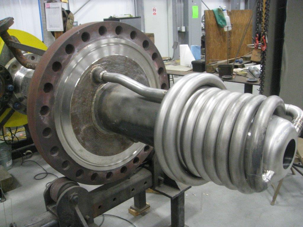 A large metal object is sitting on a table in a factory.
