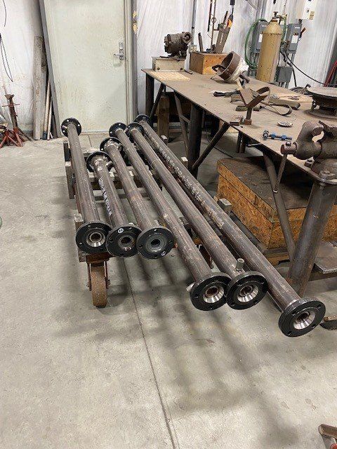 A bunch of metal pipes are stacked on top of each other in a room.