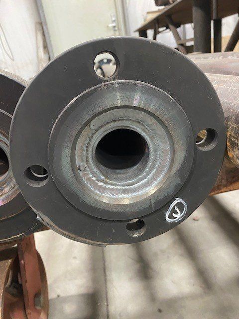 A close up of a metal pipe with a flange on it.