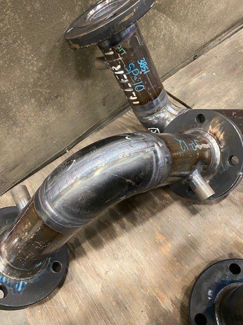 A close up of a metal pipe sitting on top of a wooden table.