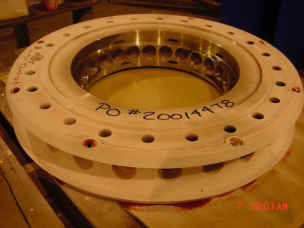 A circular piece of metal with the number 20011418 written on it