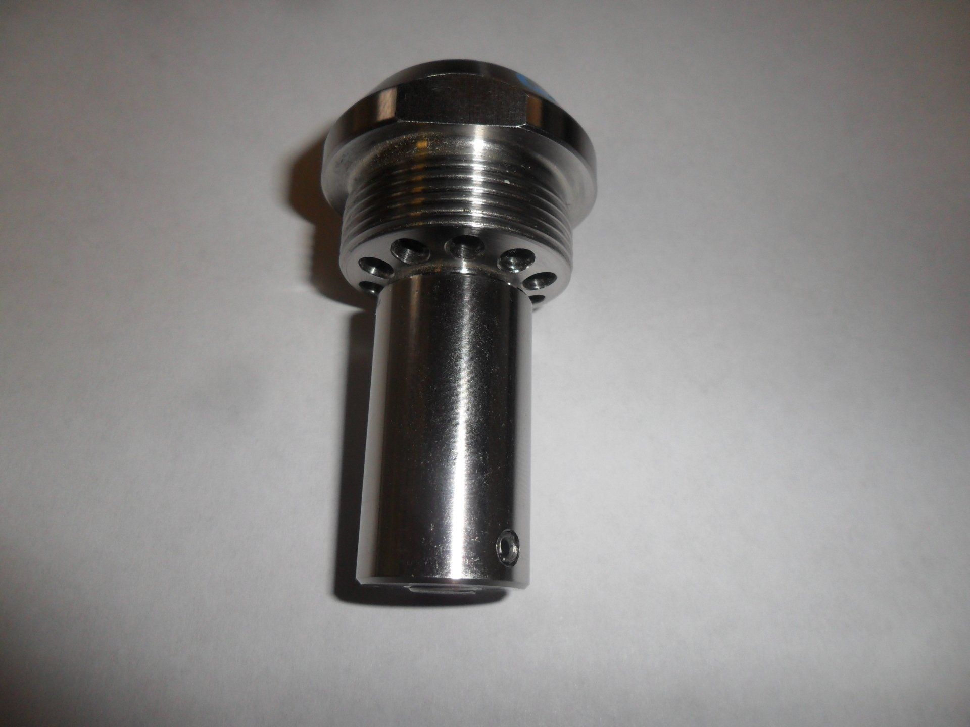 A close up of a stainless steel screw on a white surface