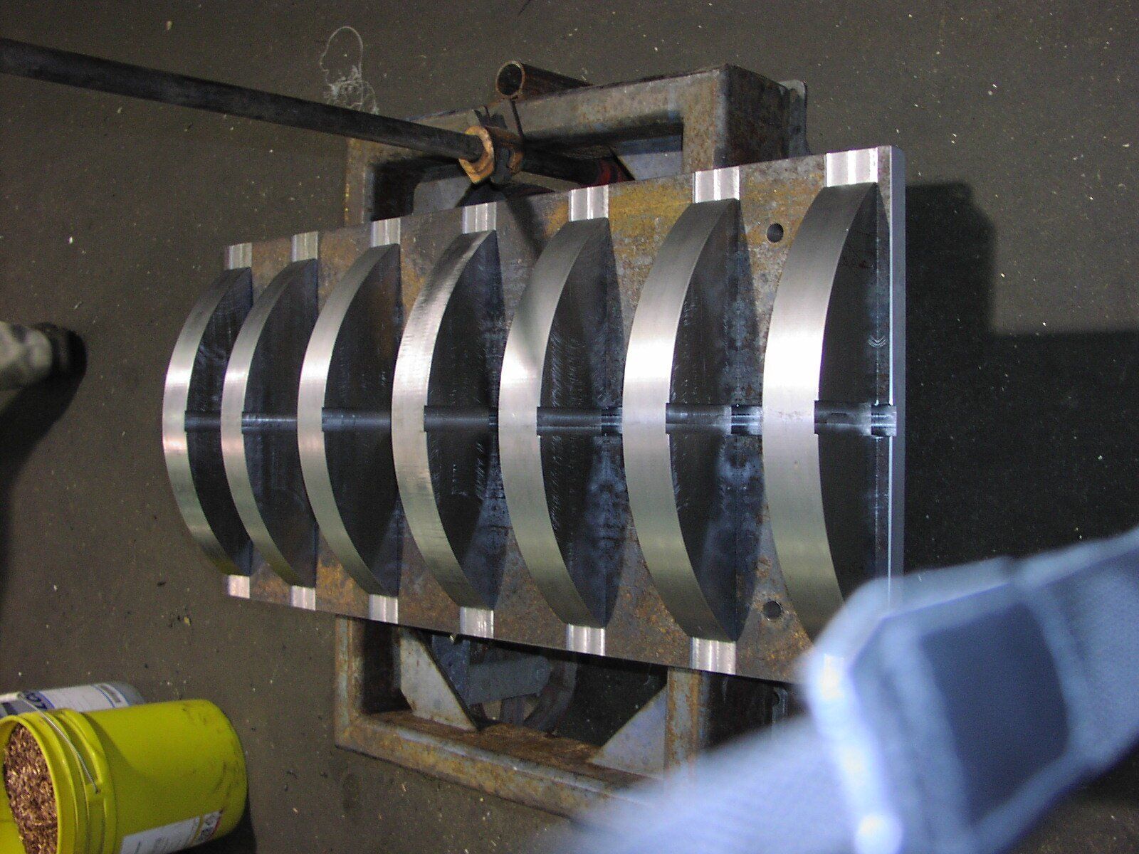 A yellow bucket sits next to a metal object
