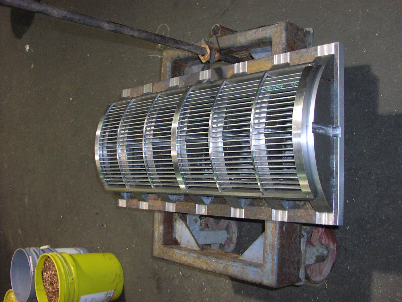 A bucket of food sits next to a large metal object