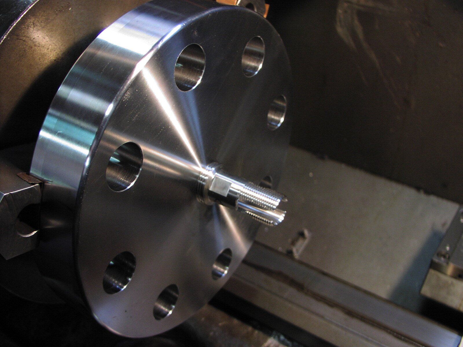 A piece of metal is being turned on a lathe