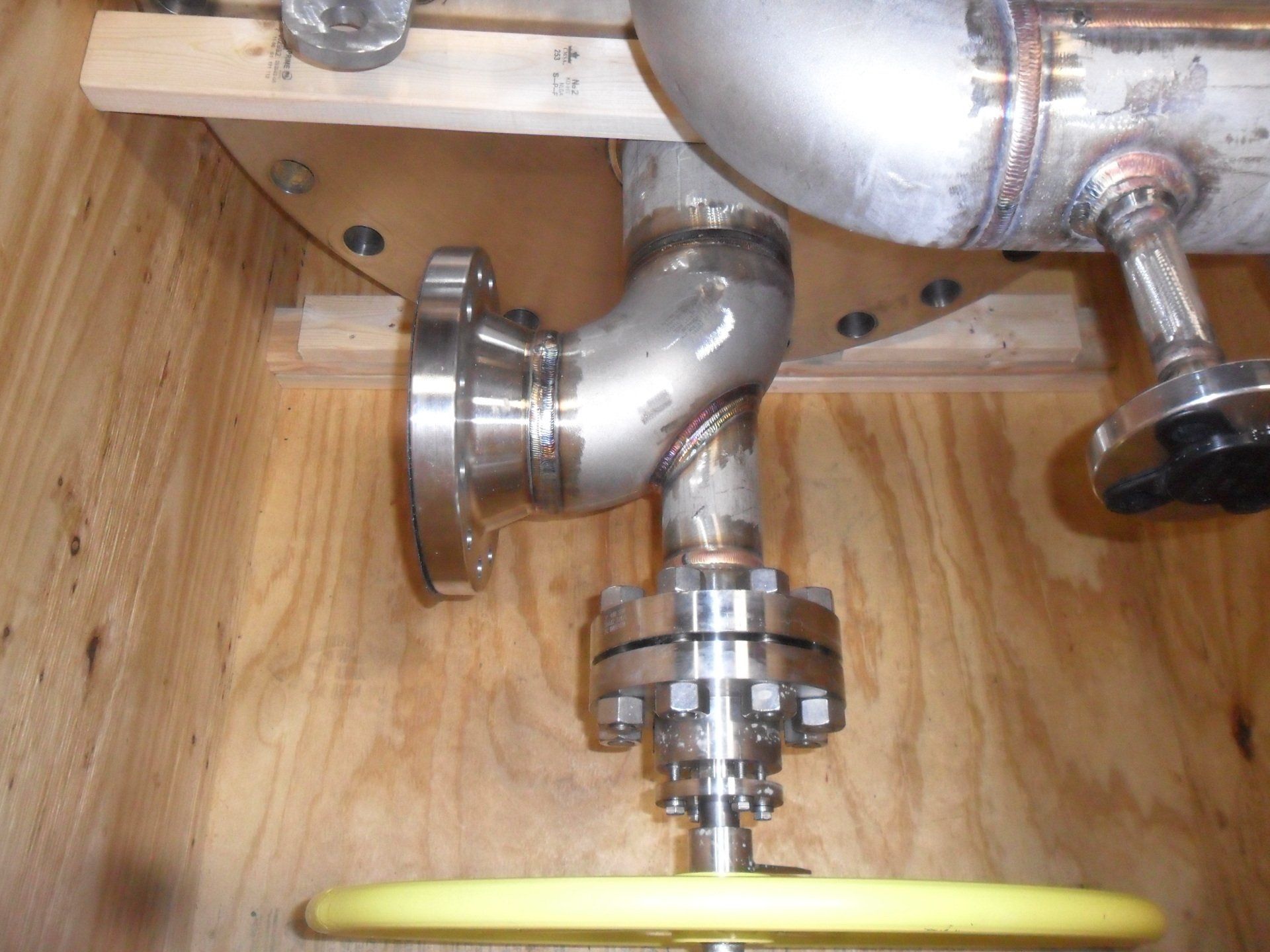 A stainless steel pipe with a yellow valve attached to it