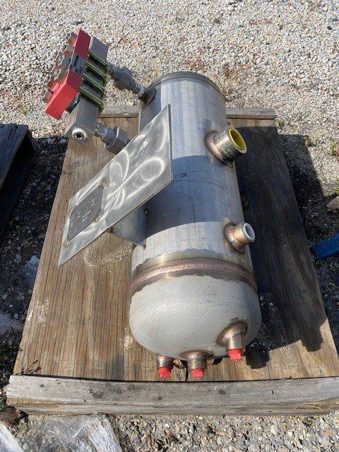 A stainless steel tank is sitting on top of a wooden table.