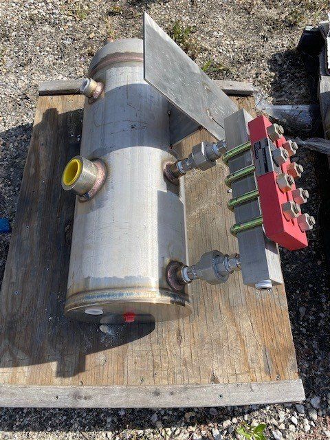 A stainless steel cylinder is sitting on a wooden table