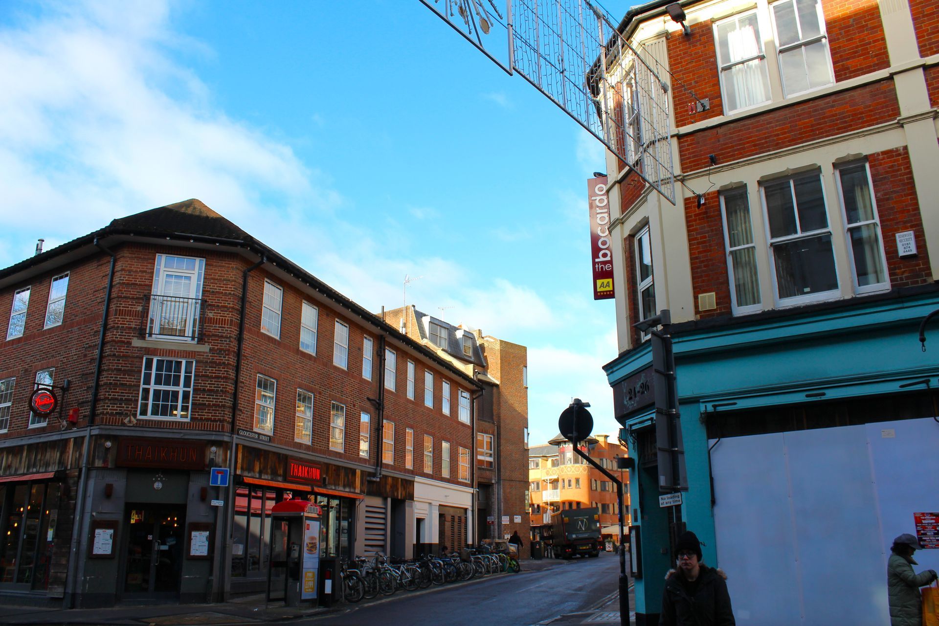Street scene with brick buildings, businesses, and blue sky.