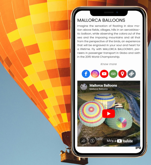 Smartphone con la página web de Mallorca Balloons, un globo aerostático al fondo, promocionando paseos en globo.