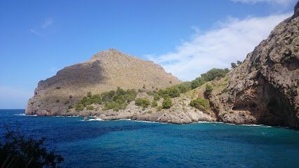 Paisaje costero con acantilados, agua azul y cielo despejado.