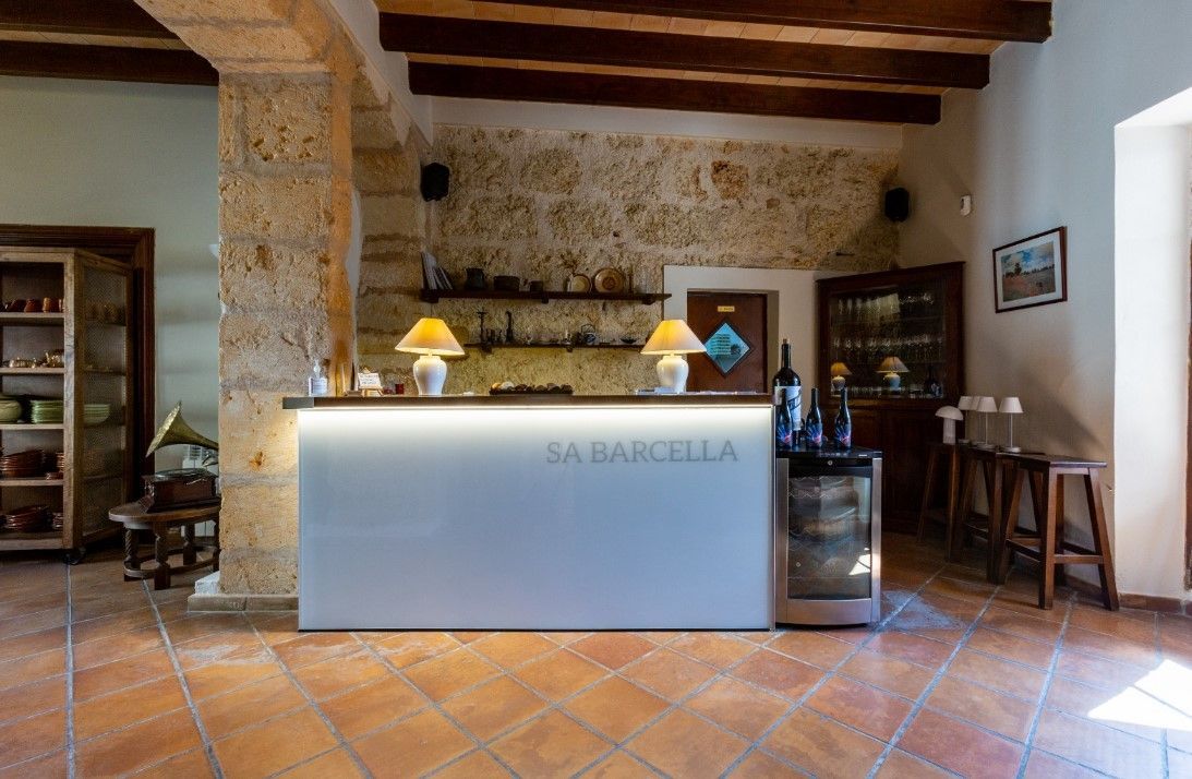 Hay un mostrador en el medio de la habitación con una botella de vino encima.
