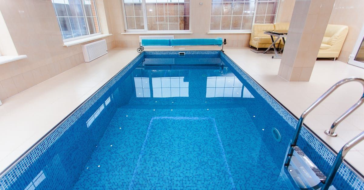 Una gran piscina cubierta llena de agua azul en una sala de estar.