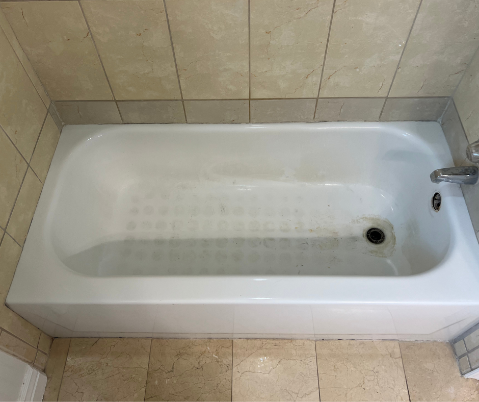 A White Bathtub Is Sitting in A Bathroom Next to A Tiled Wall — Inverness, FL — First Class Refinishing 