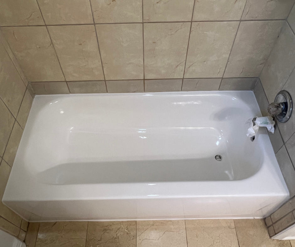 A White Bathtub Is Sitting in A Bathroom Next to A Tiled Wall — Inverness, FL — First Class Refinishing 