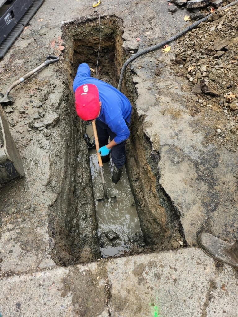 a man is digging a hole in the ground — Concord, CA — Warranted Plumbing Services Inc.