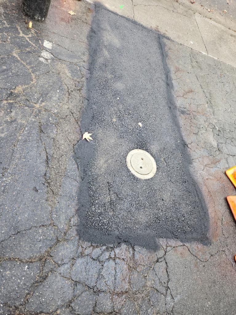 a patch of asphalt with a manhole cover in the middle — Concord, CA — Warranted Plumbing Services Inc.