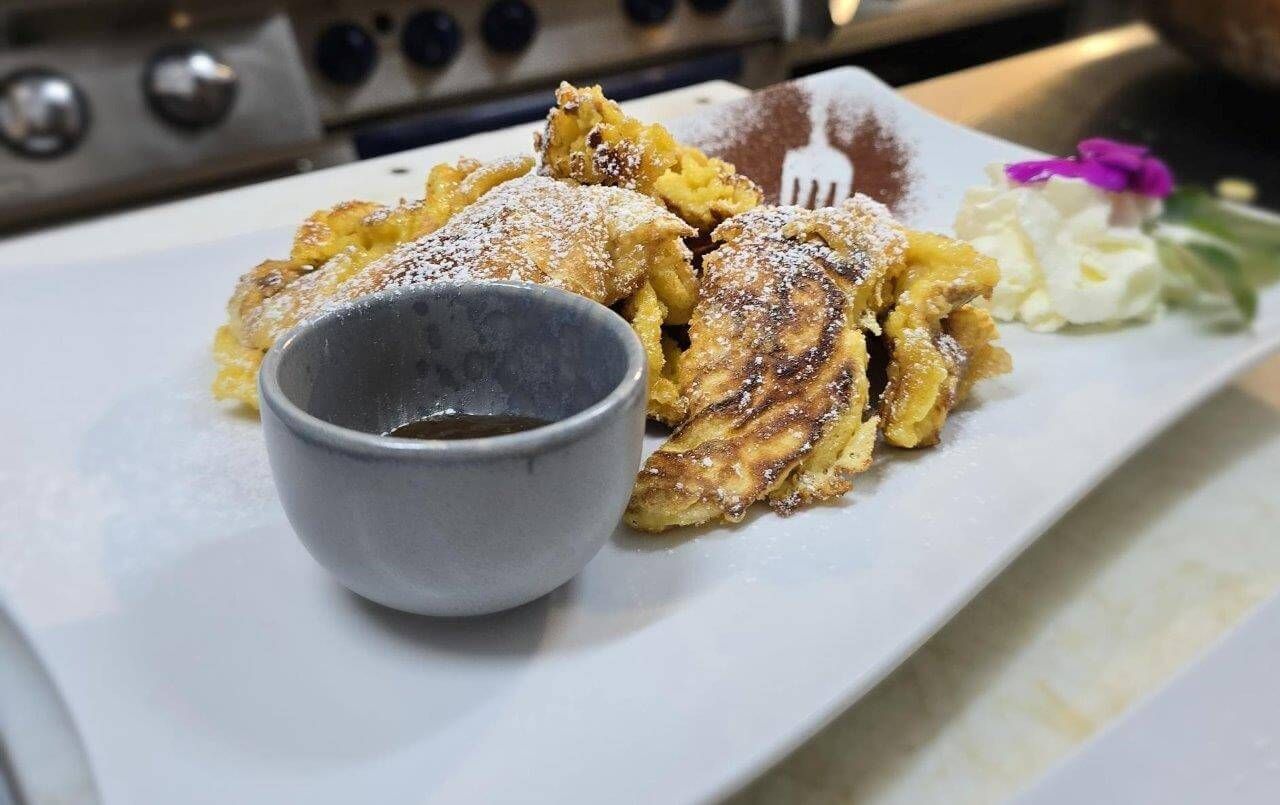 Una ciotola di cozze con pane e limone su un tavolo di legno.