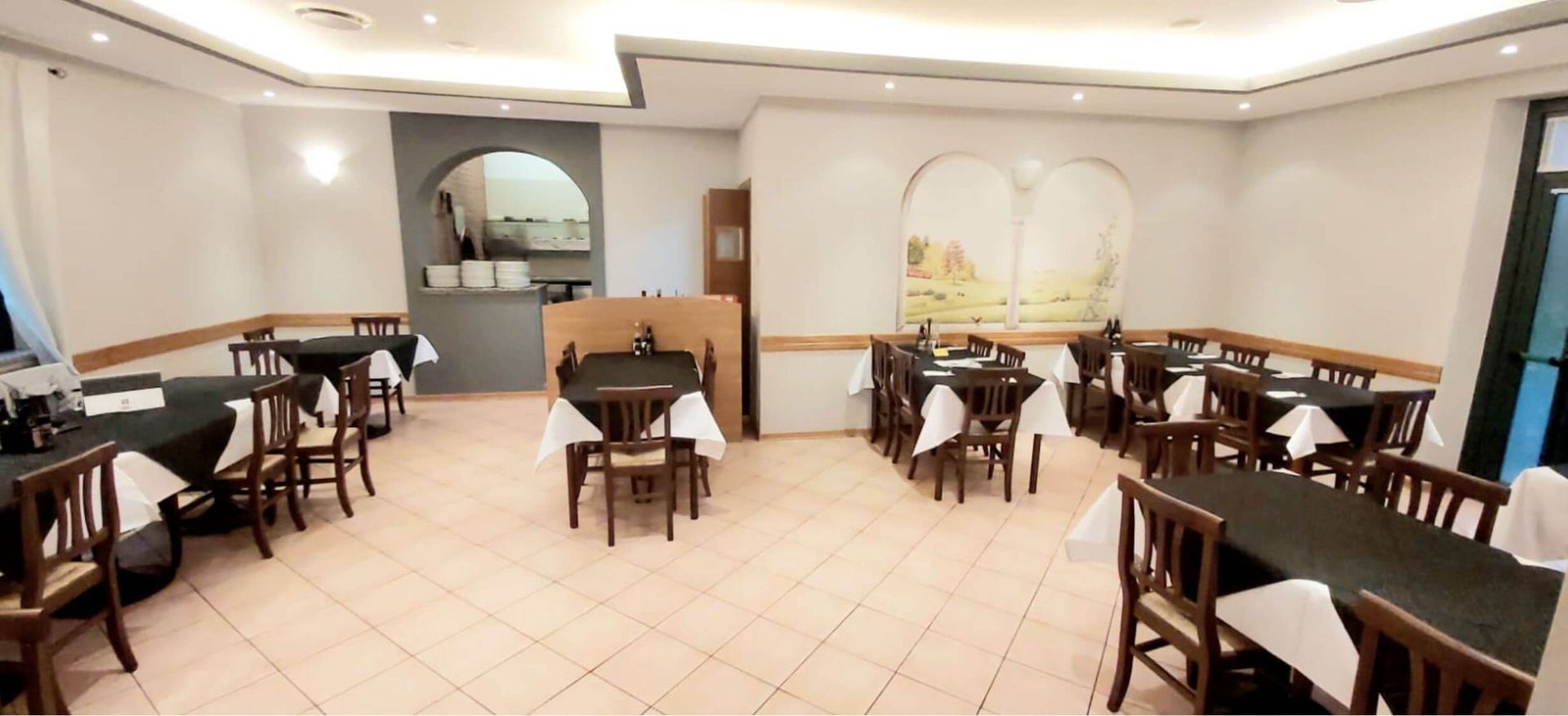 Una sala da pranzo con tavoli e sedie del ristorante pizzeria grizzley a  villa santina