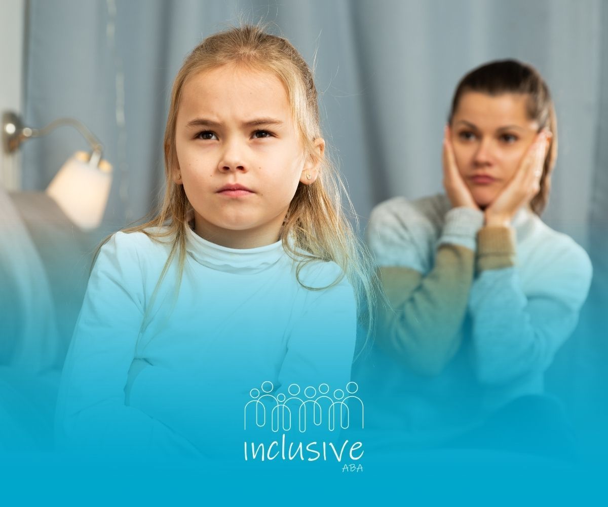 Girl with a stern expression and a woman looking distraught. Indoors, blue tones.