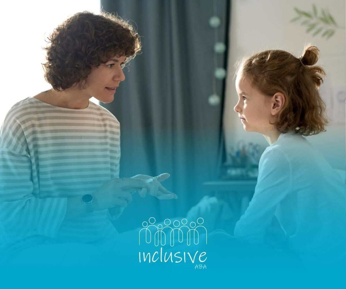 A BCBA is talking to a nonverbal girl during ABA therapy session.