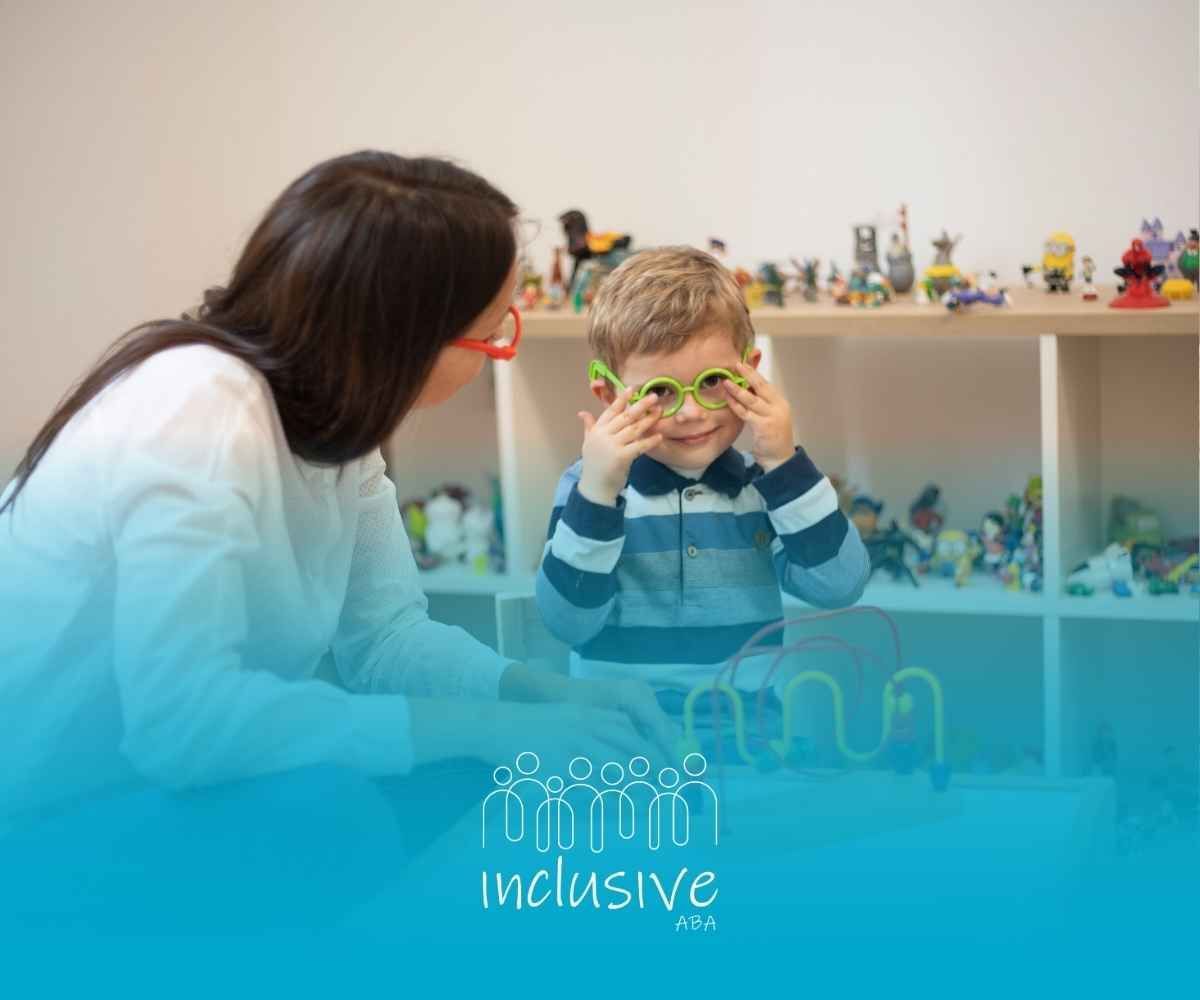 Woman and young boy wearing glasses, playing with a wooden maze toy in a room with shelves of toys.