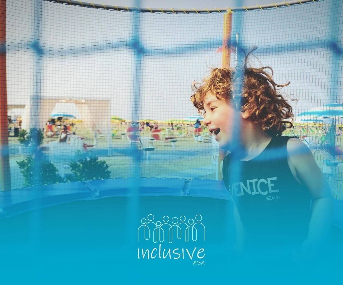Autistic child smiling while playing on trampoline at the beach.
