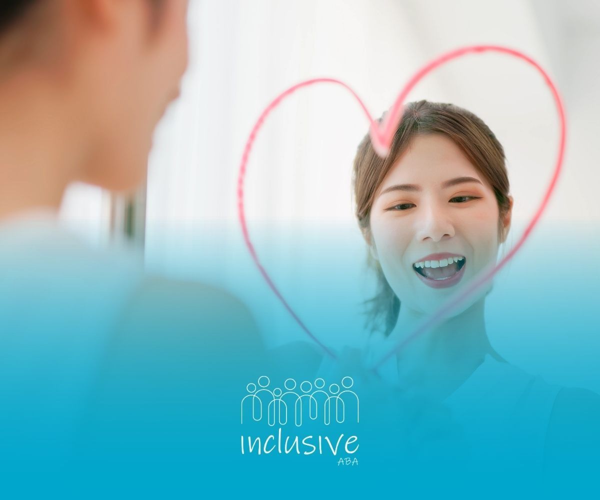 Woman smiles at herself in mirror, red heart drawn on the glass, blue background.