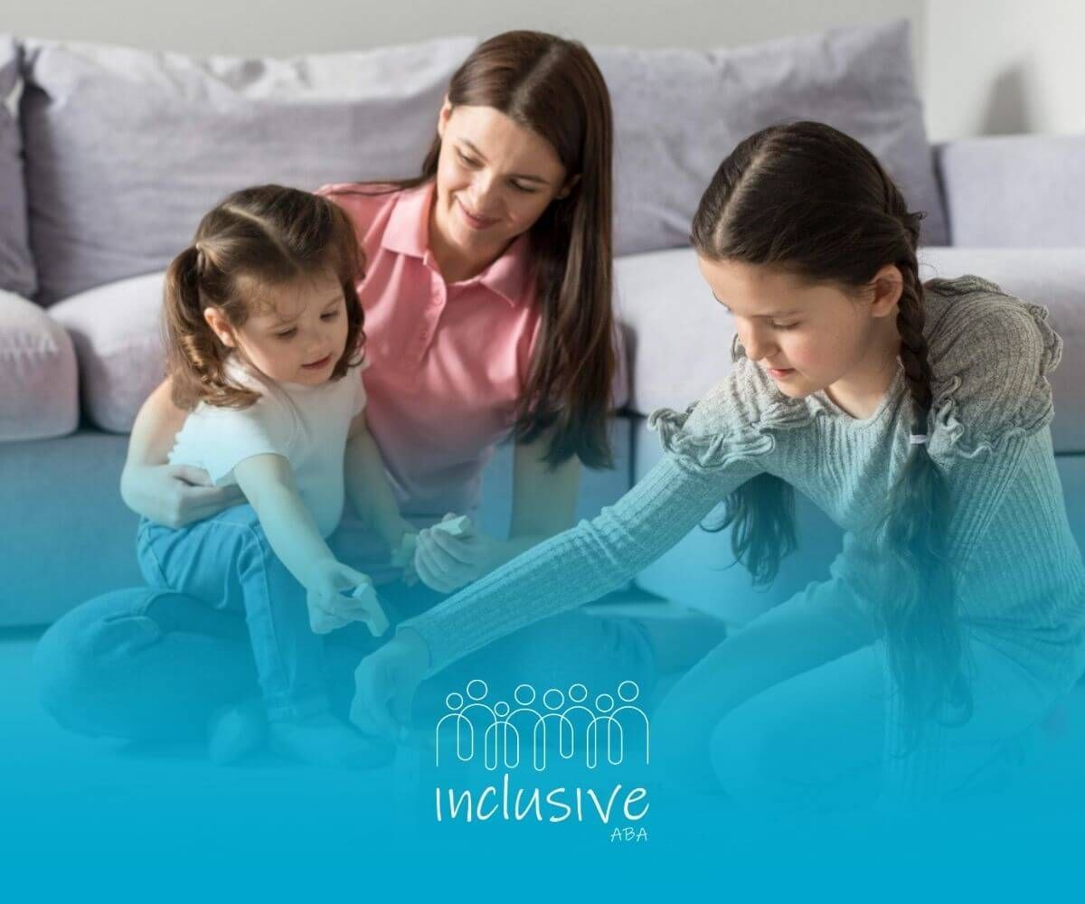 A BCBA and two children playing a stacking game together on the floor in ABA therapy.