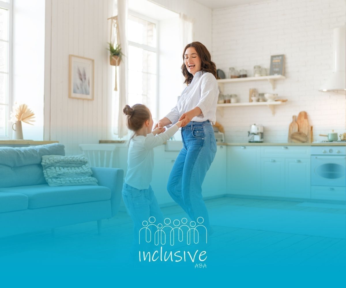 Woman and child dancing in a bright kitchen, laughing. White and blue interior.