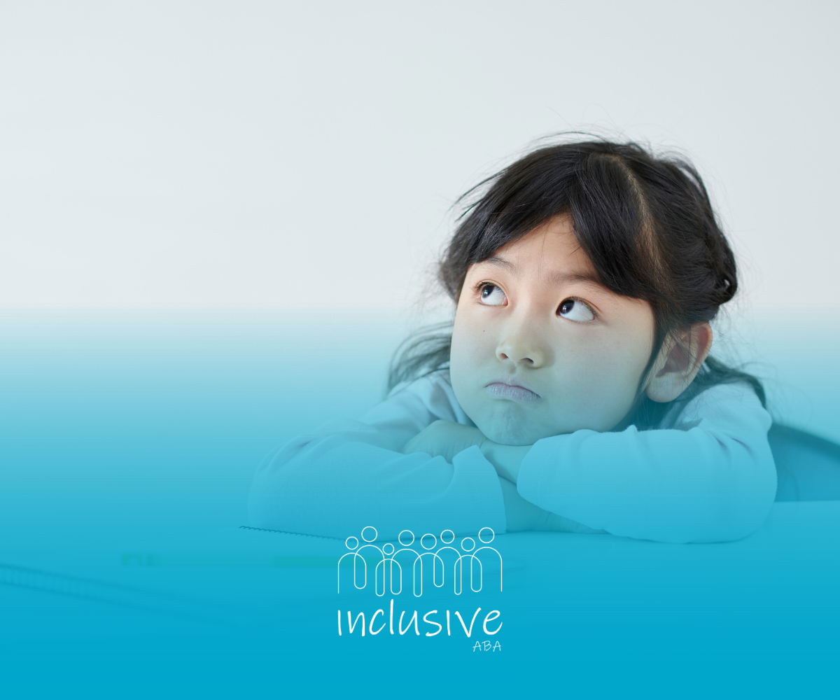 A young Asian girl rests her chin on her hands, looking up with a contemplative expression. Teal background.