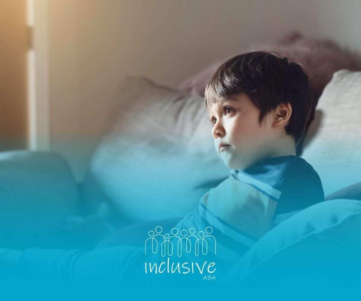 Child with autism lying on a couch and staring off thoughtfully.