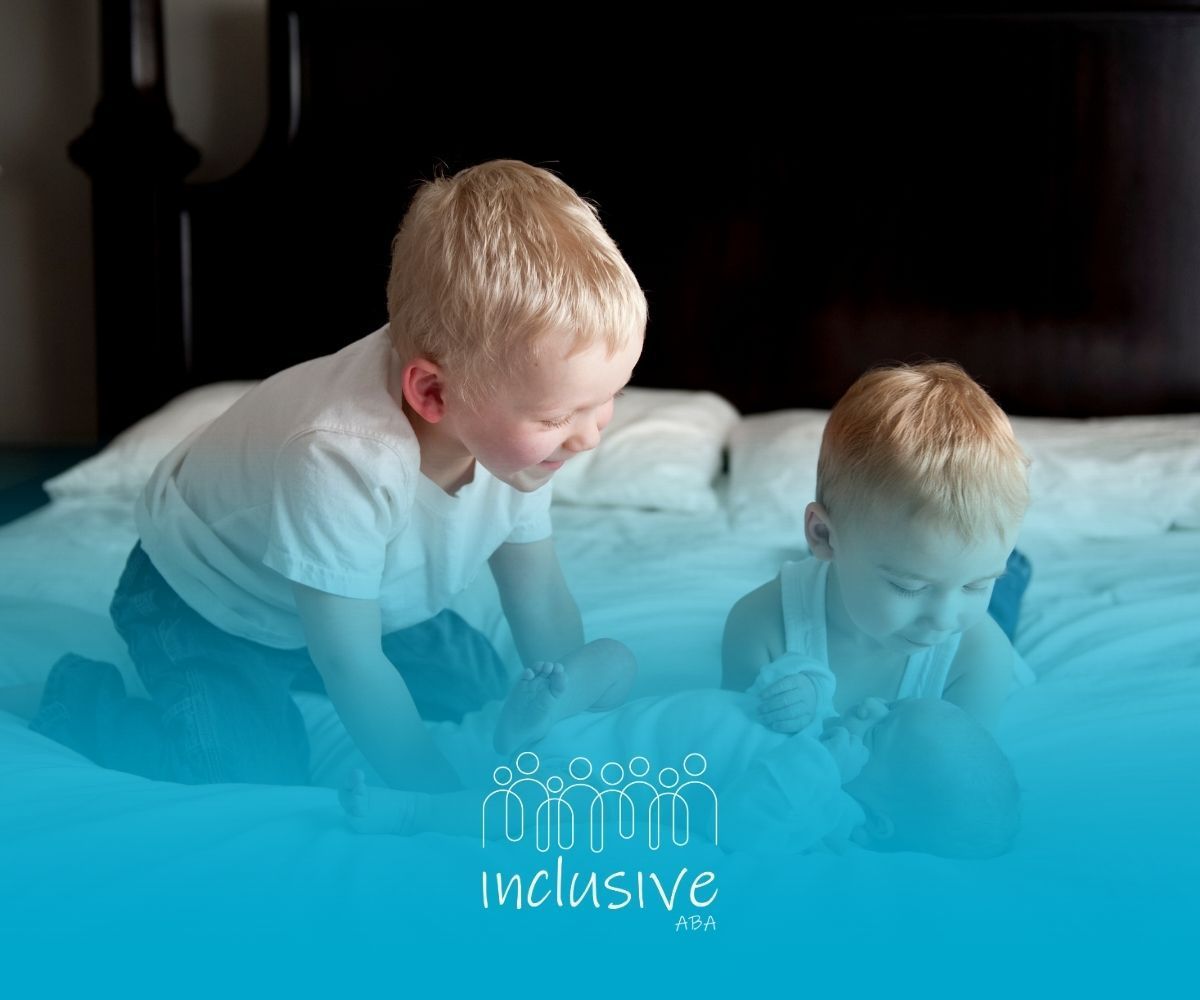 Two young children look down at an infant on a bed. Blue tint, 