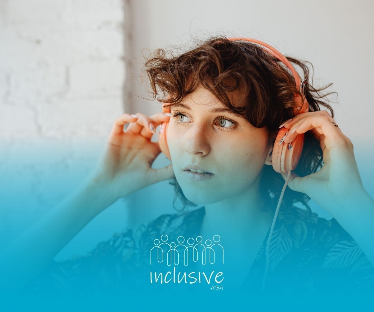 Woman with curly brown hair adjusts orange headphones, listening attentively.