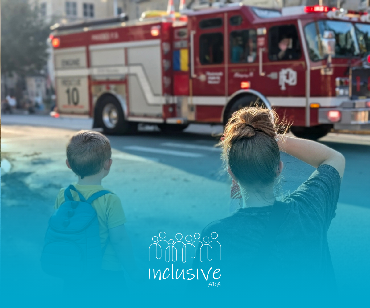 A person and a child with a backpack watch a fire engine drive by in an outdoor setting.