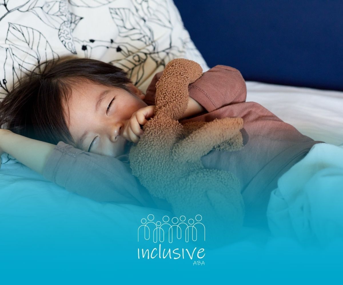 Child asleep on bed, holding a brown teddy bear, wearing a brown shirt, with a white blanket.