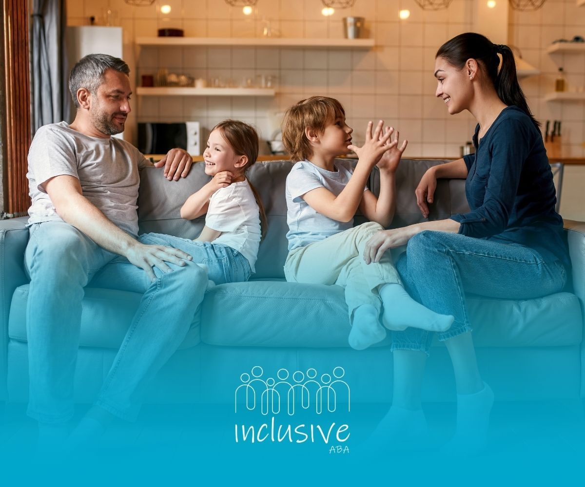 Family of four seated on a sofa, conversing in a home setting.